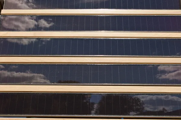 Linhas de painéis solares em relevo, árvores de céu de reflexão — Fotografia de Stock
