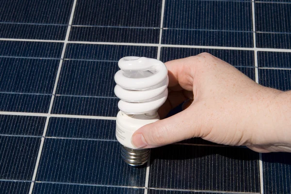 Hand Compact Fluorescent Light Bulbs Solar Panel — Stock Photo, Image