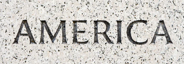 Słowo "Ameryka" rzeźbione w kamieniu granit szary — Zdjęcie stockowe