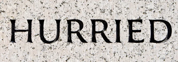 Word "Hurried" Carved in Gray Granite Stone — Stock Photo, Image