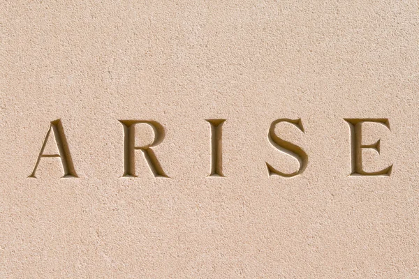 Λέξη "arise" λαξευμένη σε πέτρα ψαμμίτη — Φωτογραφία Αρχείου