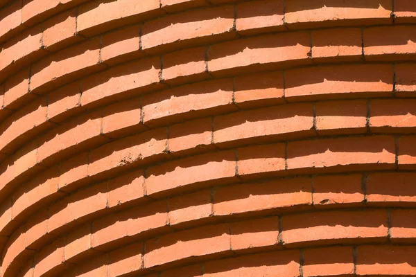 Pełna klatka zakrzywione cegieł w wierszu budynku streszczenie — Zdjęcie stockowe
