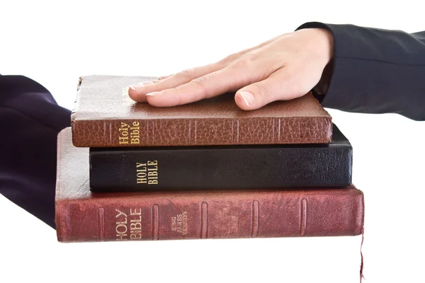 Női kéz halom Bibliák, elszigetelt háttér — Stock Fotó