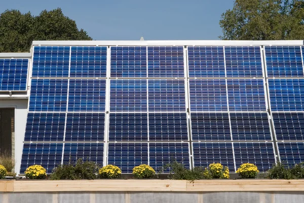 Рядок з сонячними батареями на даху проти синього неба — стокове фото