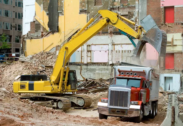 Carregador de front-end caindo materiais de demolição — Fotografia de Stock