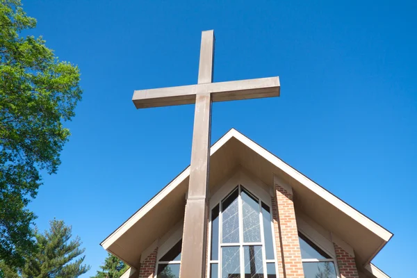 Vysoký kříž s moderním kostelem v pozadí — Stock fotografie