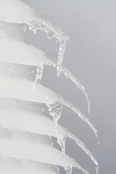 Stock image Row of Icicles Hanging off a Roof Gray Sky Background