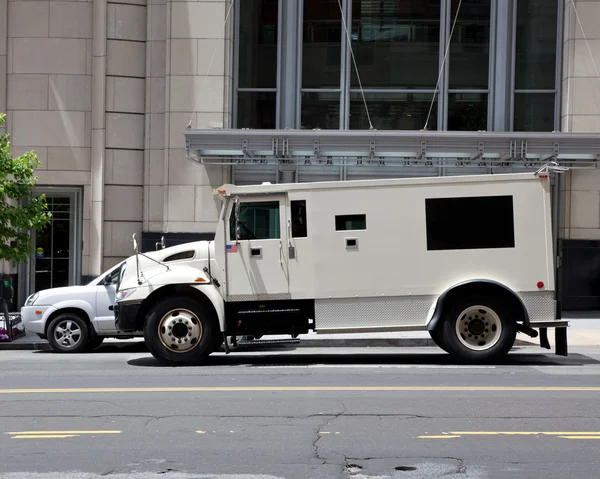 Zijaanzicht gepantserde gepantserde auto geparkeerd op straat buiten gebouw — Stockfoto