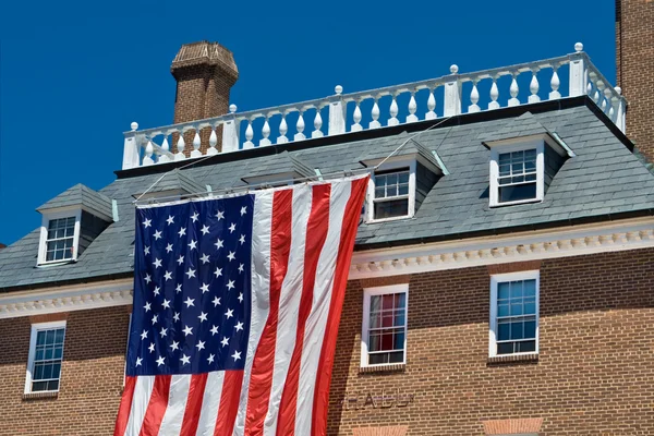 Edifício de estilo de revival colonial com grande bandeira americana Blue Sk — Fotografia de Stock