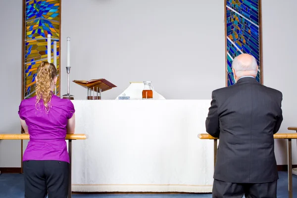 Dois Ajoelhados Caucasianos Tomando a Comunhão na Igreja Alter Fotos De Bancos De Imagens