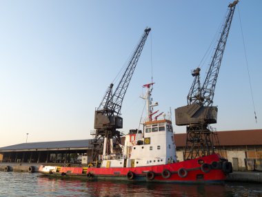 Orange tugboat in a harbor clipart