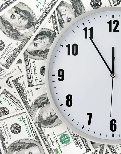 Clock with hand on money background — Stock Photo, Image