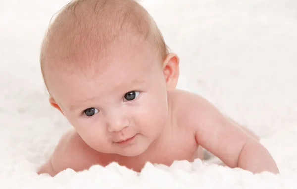 Baby on white bed — Stock Photo, Image