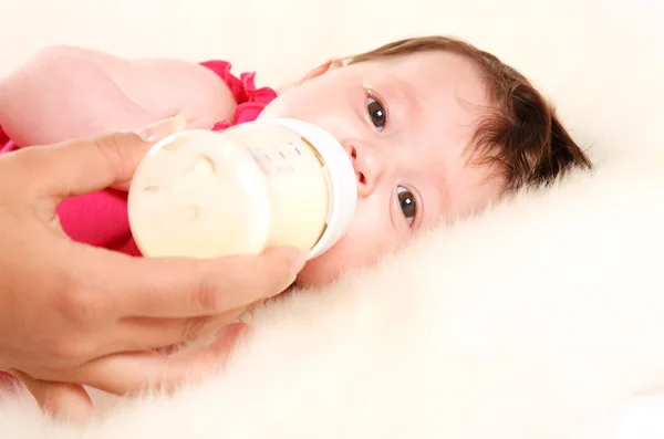 Baby meisje drinken melk uit fles — Stockfoto