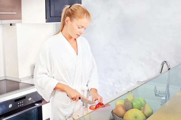 Mladá žena dělá ranní šťávu v kuchyni — Stock fotografie