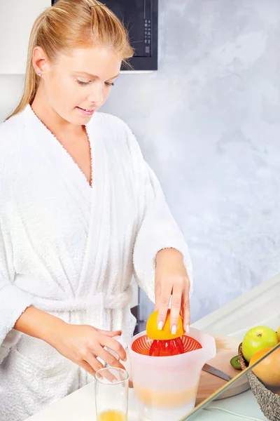 Young woman making morning juice in kitchen — Stock Photo, Image