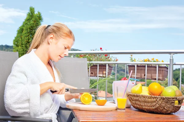 Frau macht Morgensaft auf Terrasse — Stockfoto