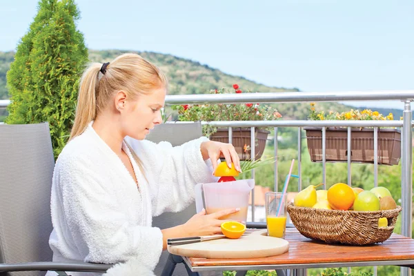 Woman making morning juice on terrace — Stock Photo, Image
