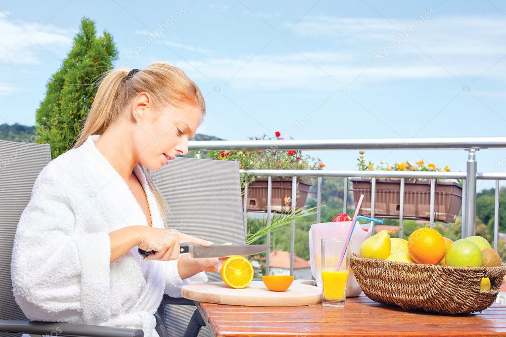 Woman making morning juice on terrace
