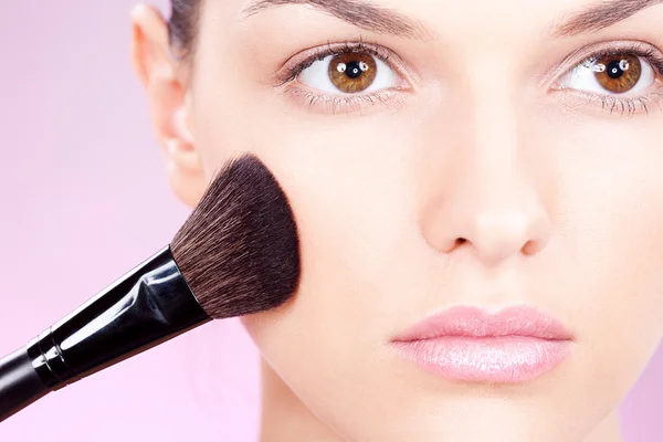 Flickan gör makeup med puderborste — Stockfoto