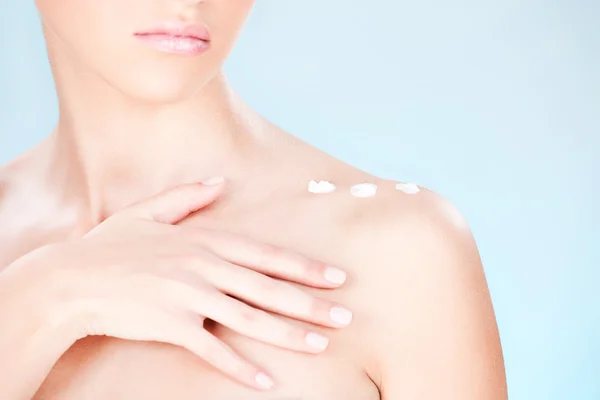 Kosmetyk krem na ramieniu kobiety — Zdjęcie stockowe