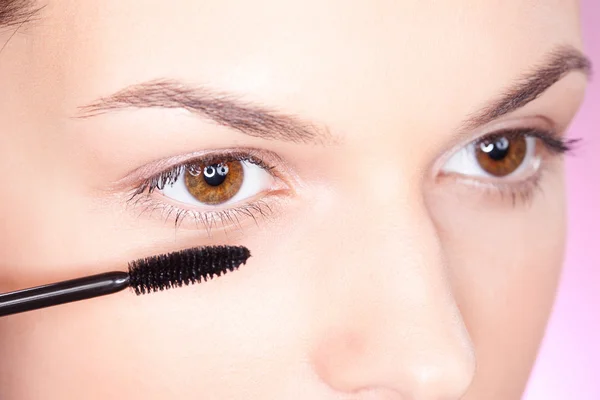 Mulher bonita aplicando rímel no olho — Fotografia de Stock