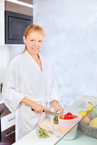 Mujer haciendo ensalada de frutas en la cocina — Foto de Stock