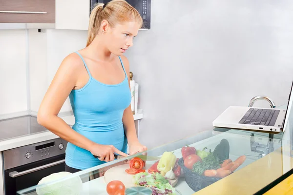 Frau in Küche mit Laptop — Stockfoto