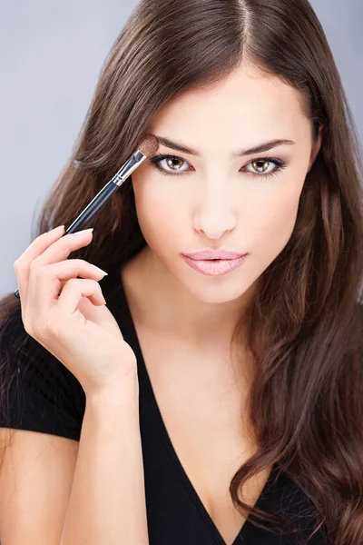 Mujer aplicando maquillaje con pincel —  Fotos de Stock