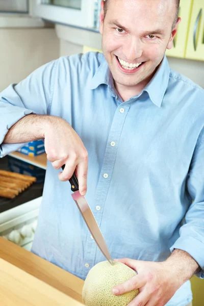 Man and melon in kitchen — Stock Photo, Image