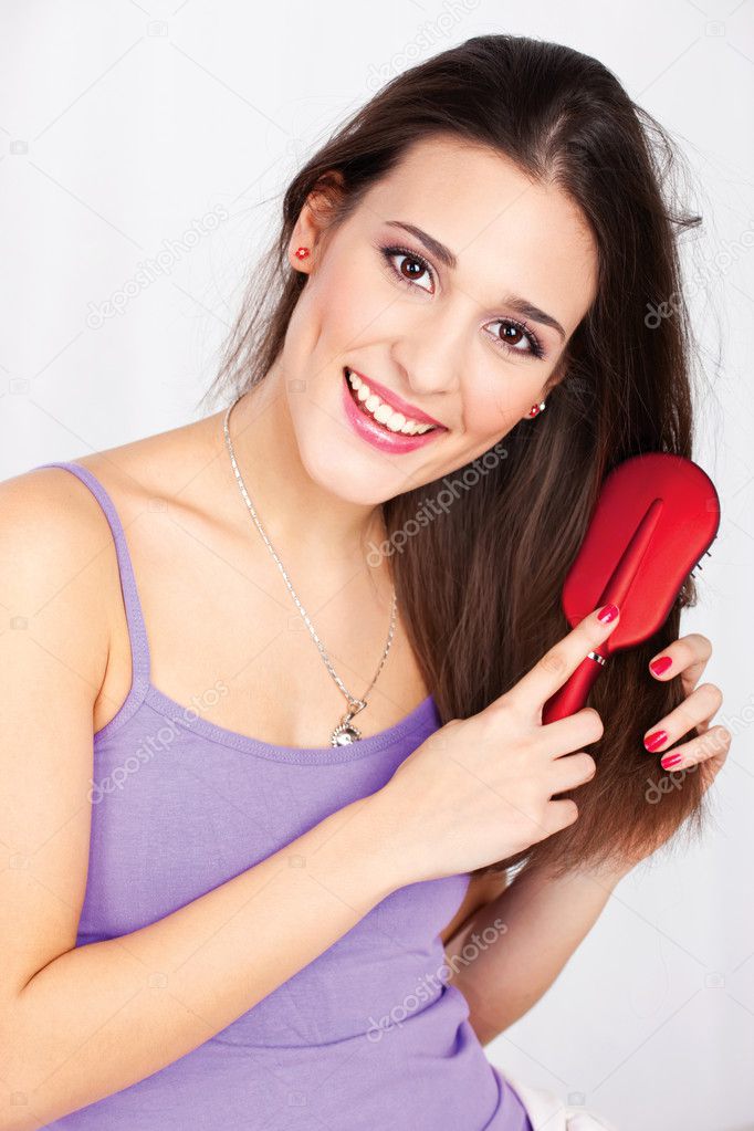 Portrait of a pretty woman combing her hair