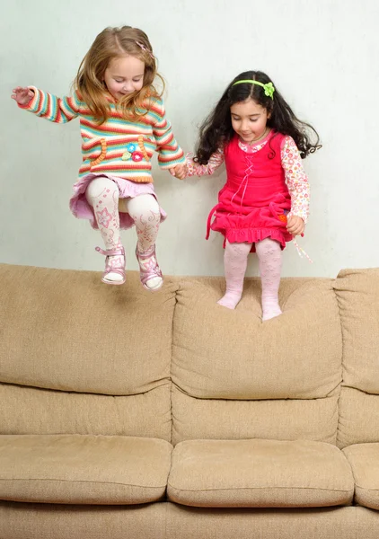 Δύο κοριτσάκια άλμα στον καναπέ — Φωτογραφία Αρχείου