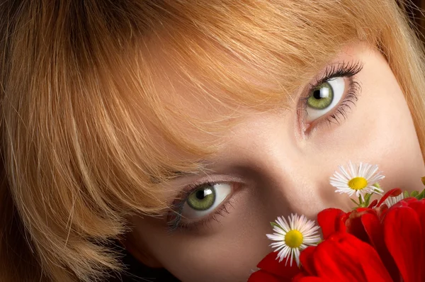 Green eyes and flowers — Stock Photo, Image