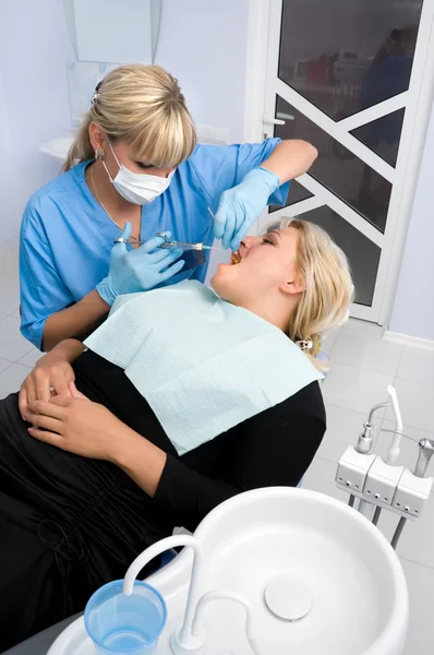 Kobieta dentysty pracuje z pacjentem w urzędzie — Zdjęcie stockowe