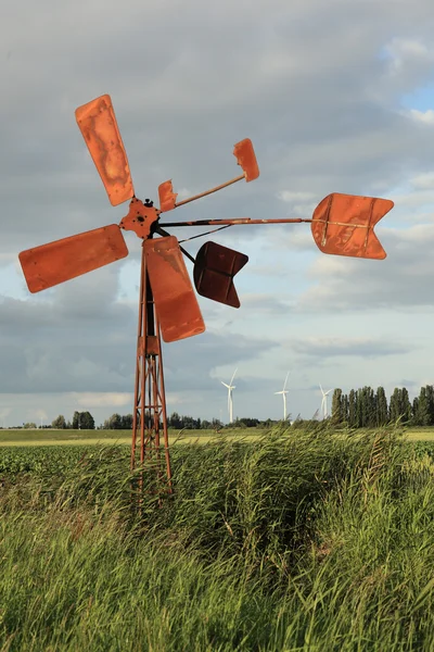 Old wind mill with modern wind turbines — Stock Photo, Image