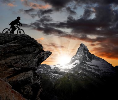 Silhouette biker in the Swiss Alps clipart