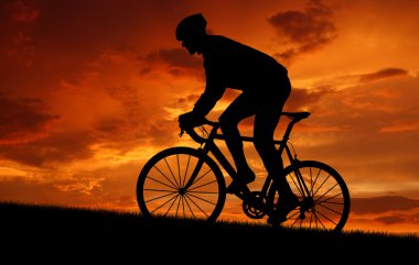 Cyclist riding a road bike at sunset