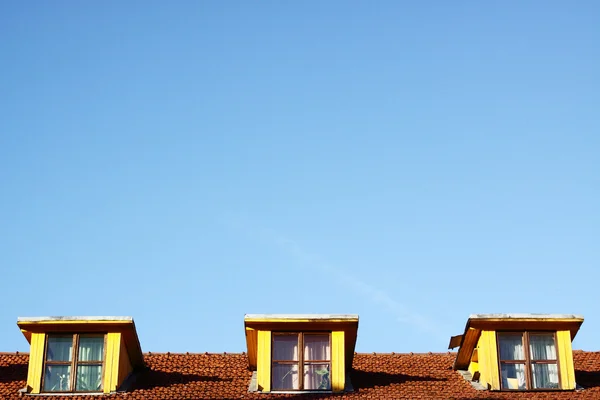 stock image Three windows on the roof under the blue sky