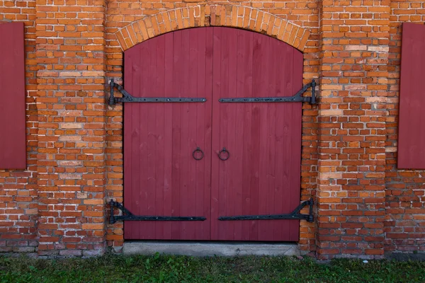 Красная дверь в красной кирпичной стене — стоковое фото