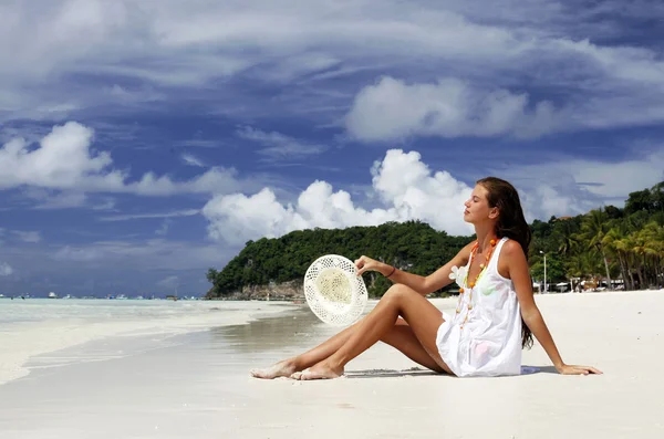 Tropikal plaj kum üzerine oturan attracrive kız — Stok fotoğraf