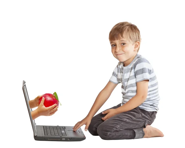 Hand met een appel en via het computerscherm — Stockfoto