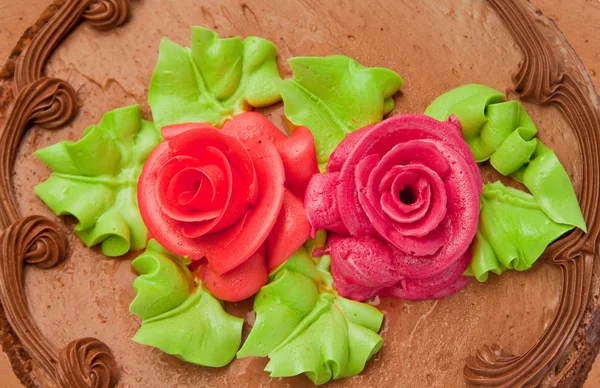 Schokoladenkuchen mit zwei cremefarbenen Rosen. isoliert auf weißem Hintergrund. — Stockfoto
