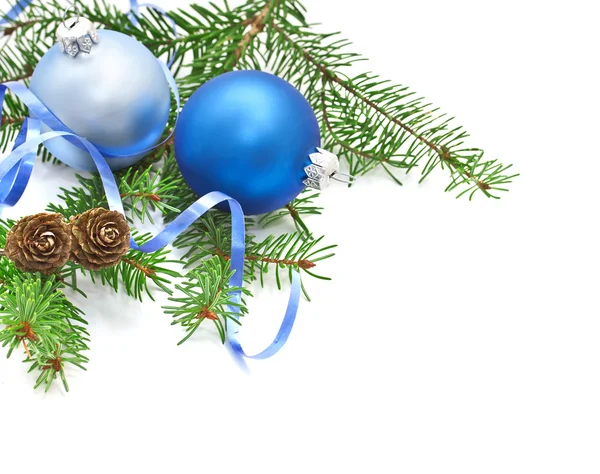 Rama de pino con conos de pino y decoraciones navideñas sobre fondo blanco — Foto de Stock