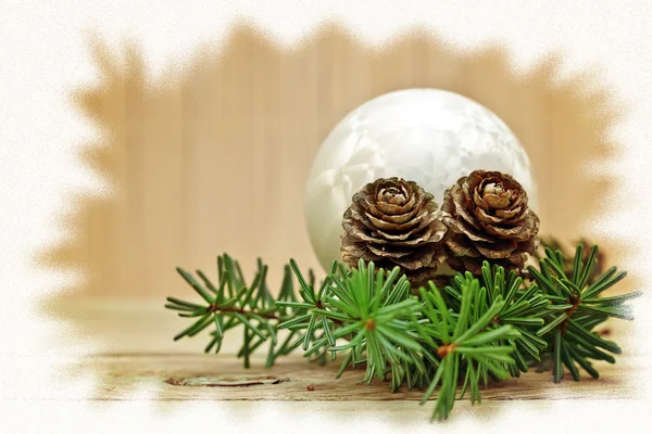 Ramo de pinheiro com cones de pinheiro e decorações de Natal em um fundo de bordo — Fotografia de Stock