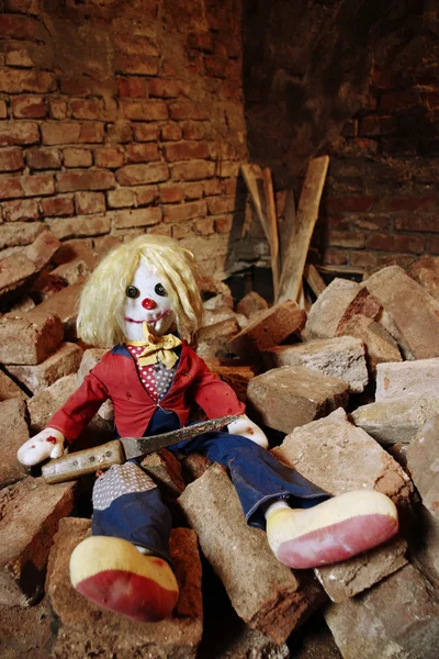 Muñeca asustadiza sentada en los ladrillos —  Fotos de Stock