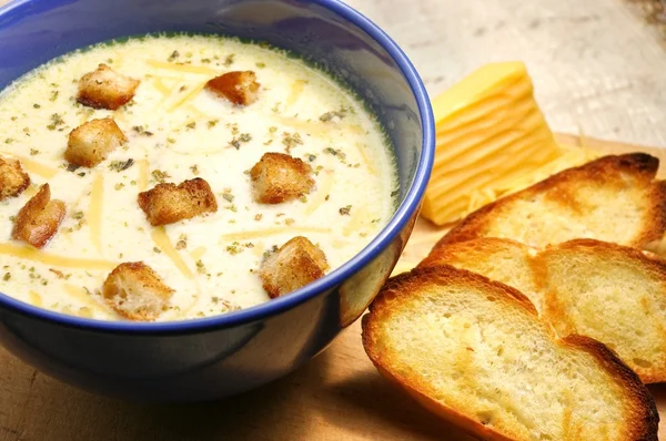 Cheese soup with toasts in blue pottery — Stock Photo, Image