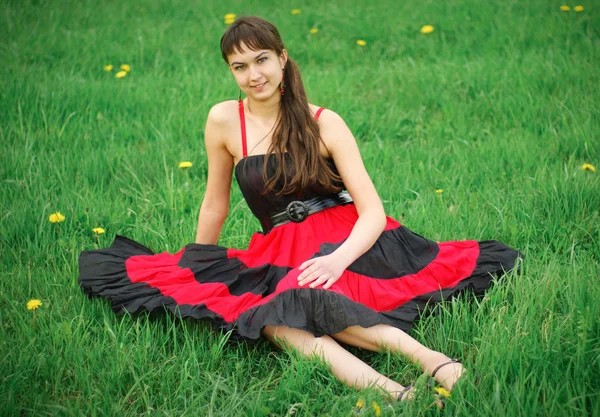 Menina em vestido vermelho na grama — Fotografia de Stock