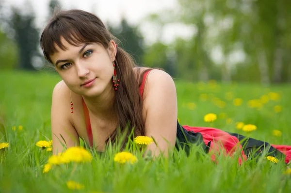 Gipsy girl on the meadow with dandelion flowers — Stock Photo, Image