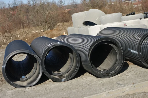 Grandes tubos pretos na área de construções — Fotografia de Stock