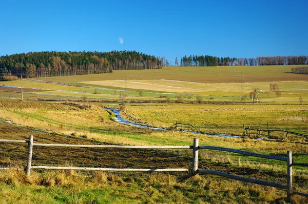 Meadows scenery with fence on first plan — Stock Photo, Image